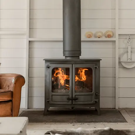 Charnwood Island III closed combustion cast iron stove with twin glass doors and roaring flames